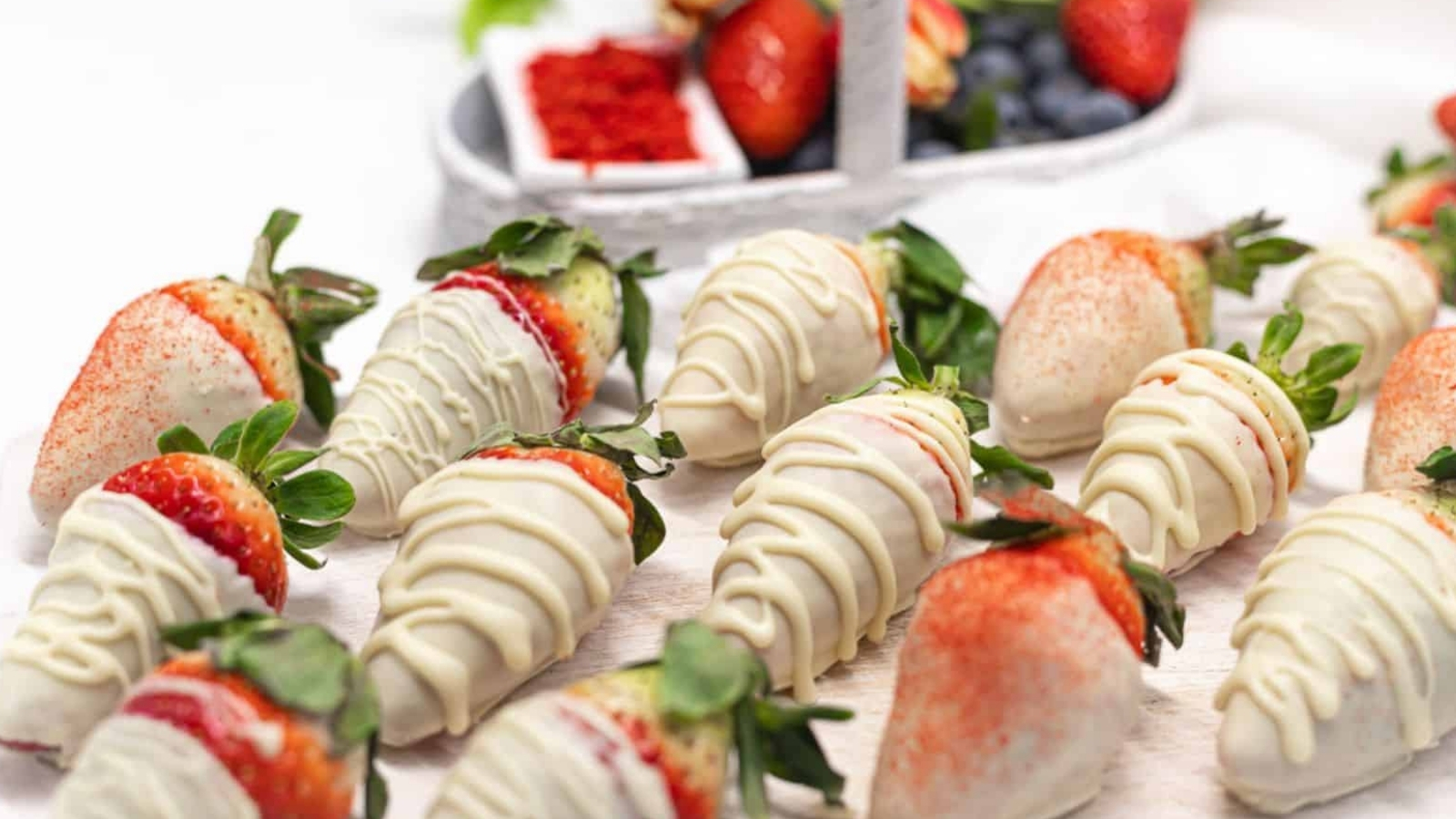 White Chocolate Covered Strawberries on a white wooden board.