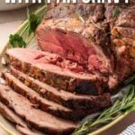 Sliced lamb roast served on a plate with herbs, accompanied by a bowl of gravy; text overlay reads "How to Make a Lamb Roast with Pan Gravy.