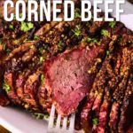 Sliced smoked and braised corned beef garnished with herbs on a white platter, with a fork inserted and text about the recipe on top and bottom.