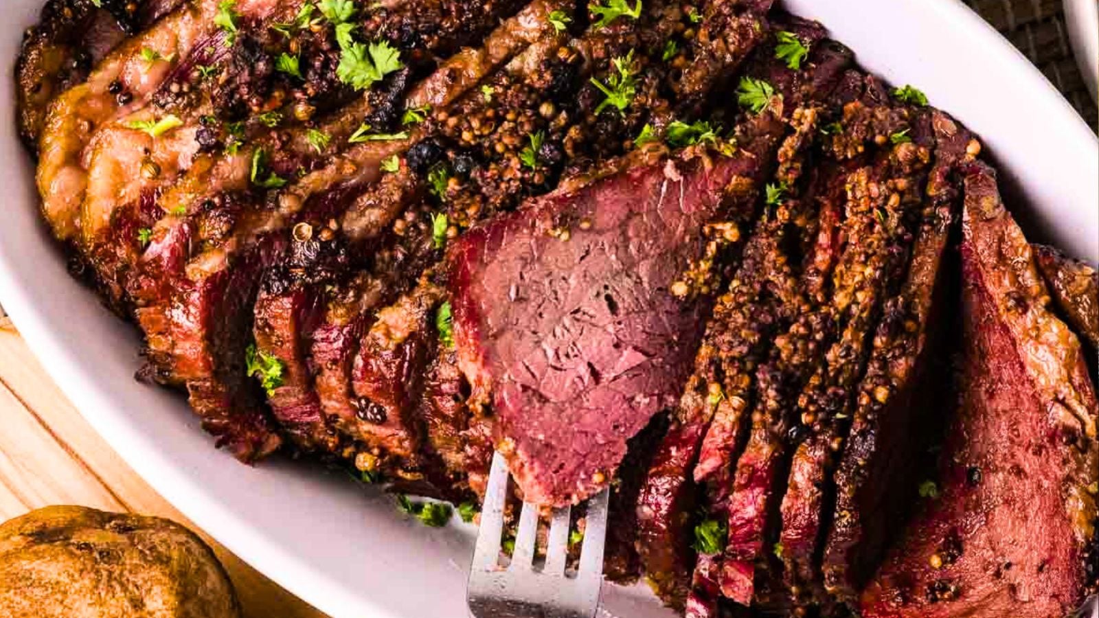 Smoked corned beef sliced showing pink cured interior and dark smoky crust.
