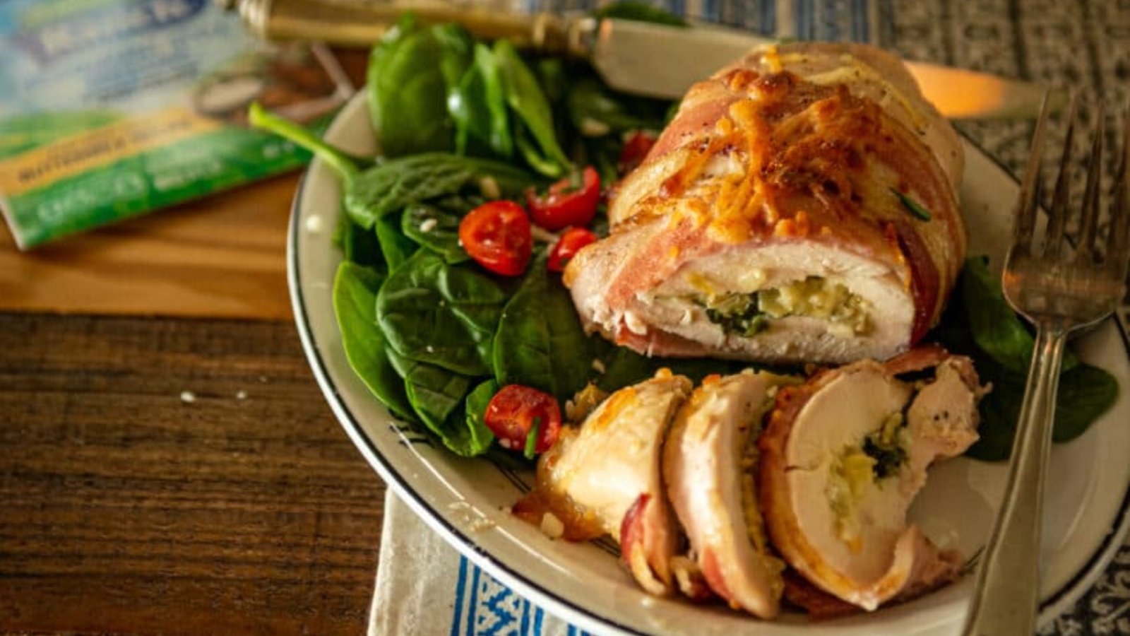 Chicken breast stuffed and wrapped in bacon baked golden with melted filling exposed.