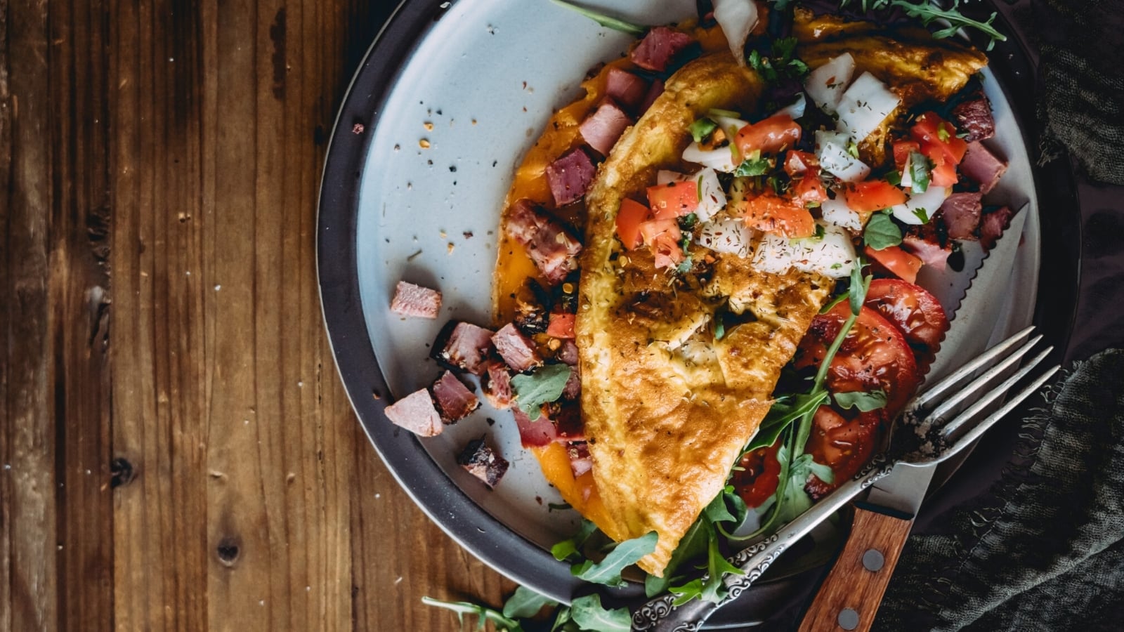 Ham and cheese omelette folded with melted cheese spilling from inside.