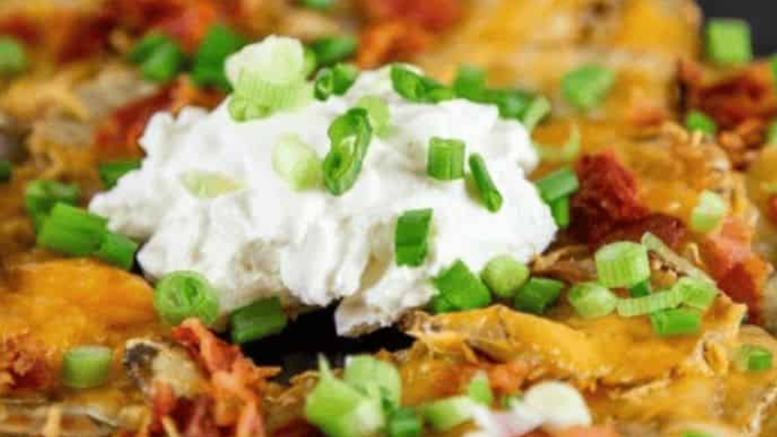 Potato rounds topped with cheese, bacon, sour cream, and green onions.