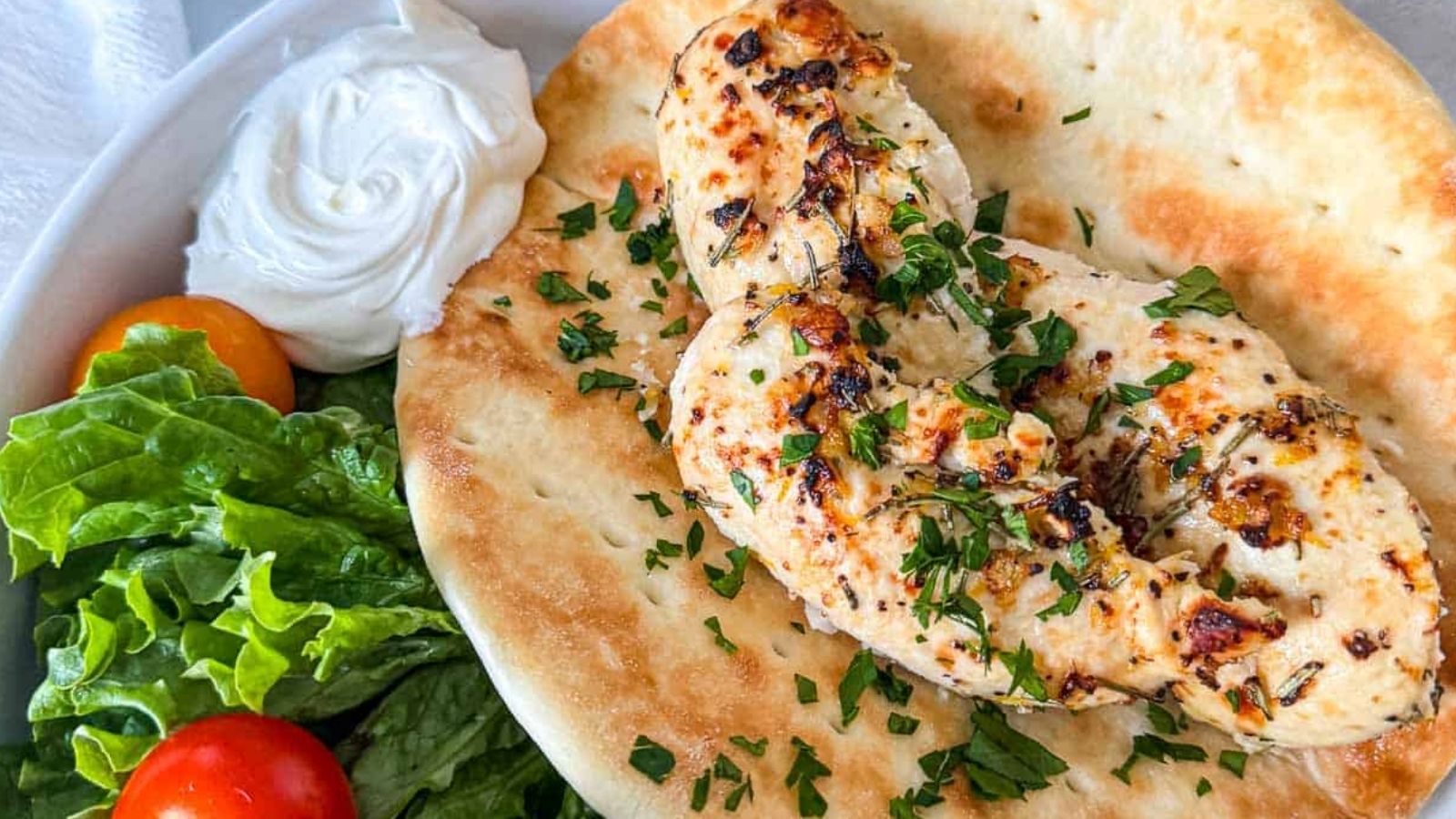 Chicken in a wrap with lettuce and tomatoes.