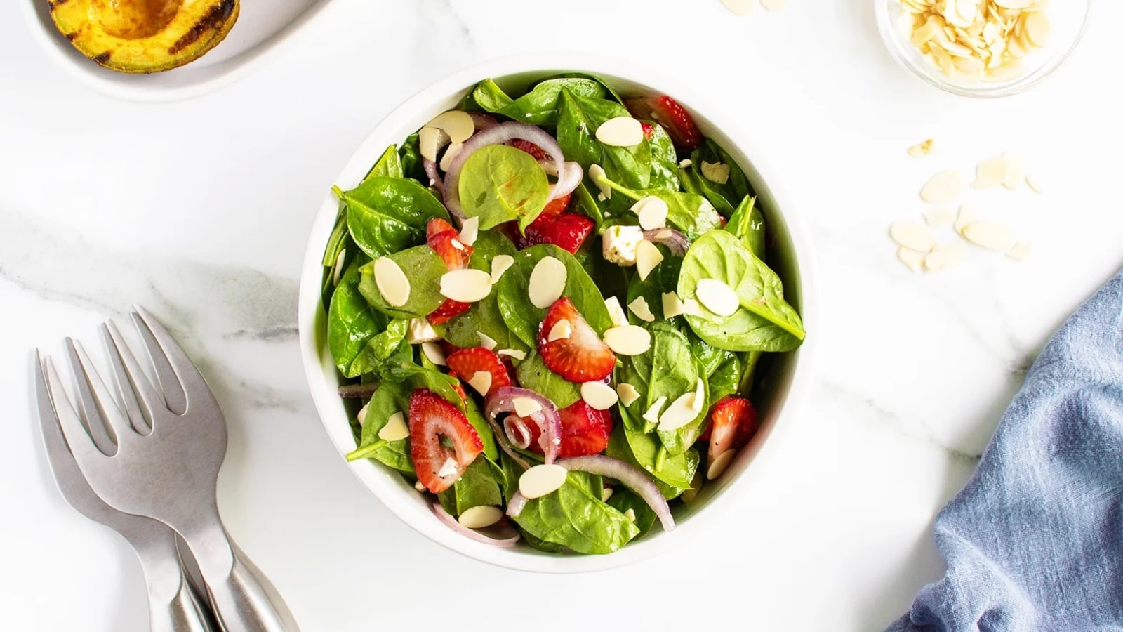 Strawberry spinach salad with fresh strawberries, spinach, and toppings in a bowl.