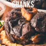 A braised beef shank with a bone in the center is served on mashed potatoes, drizzled with stout and coffee sauce, with text overlay about the recipe.