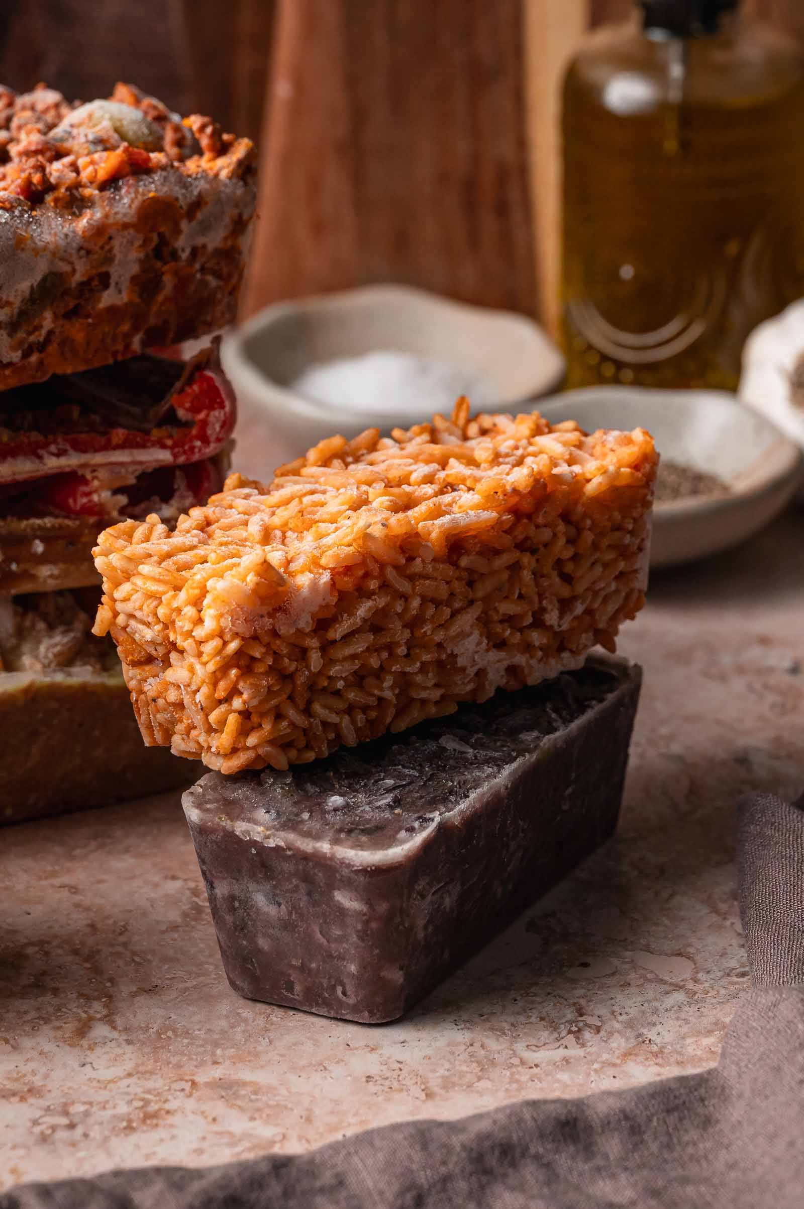 Two frozen blocks of spanish rice and cuban black beans, are stacked on a countertop.