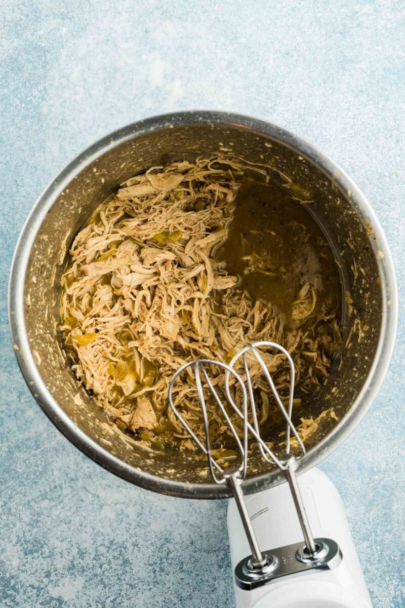 Shredded chicken that was torn using a hand mixer in the instant pot bowl.