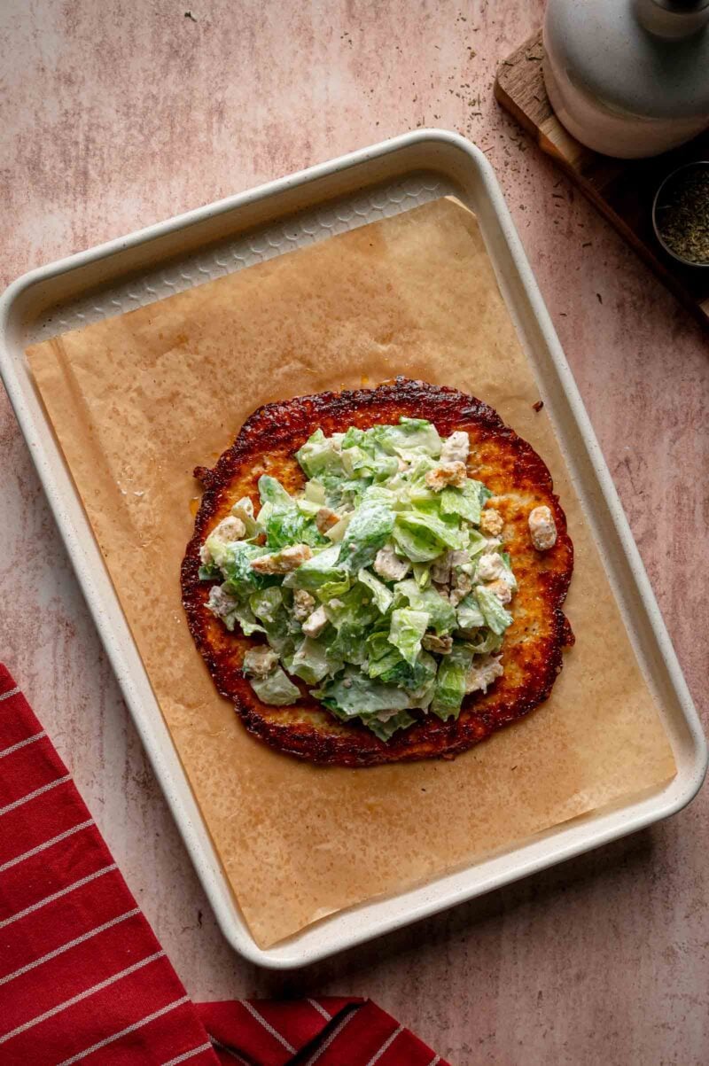 Caesar salad piled on top of the pizza wrap.
