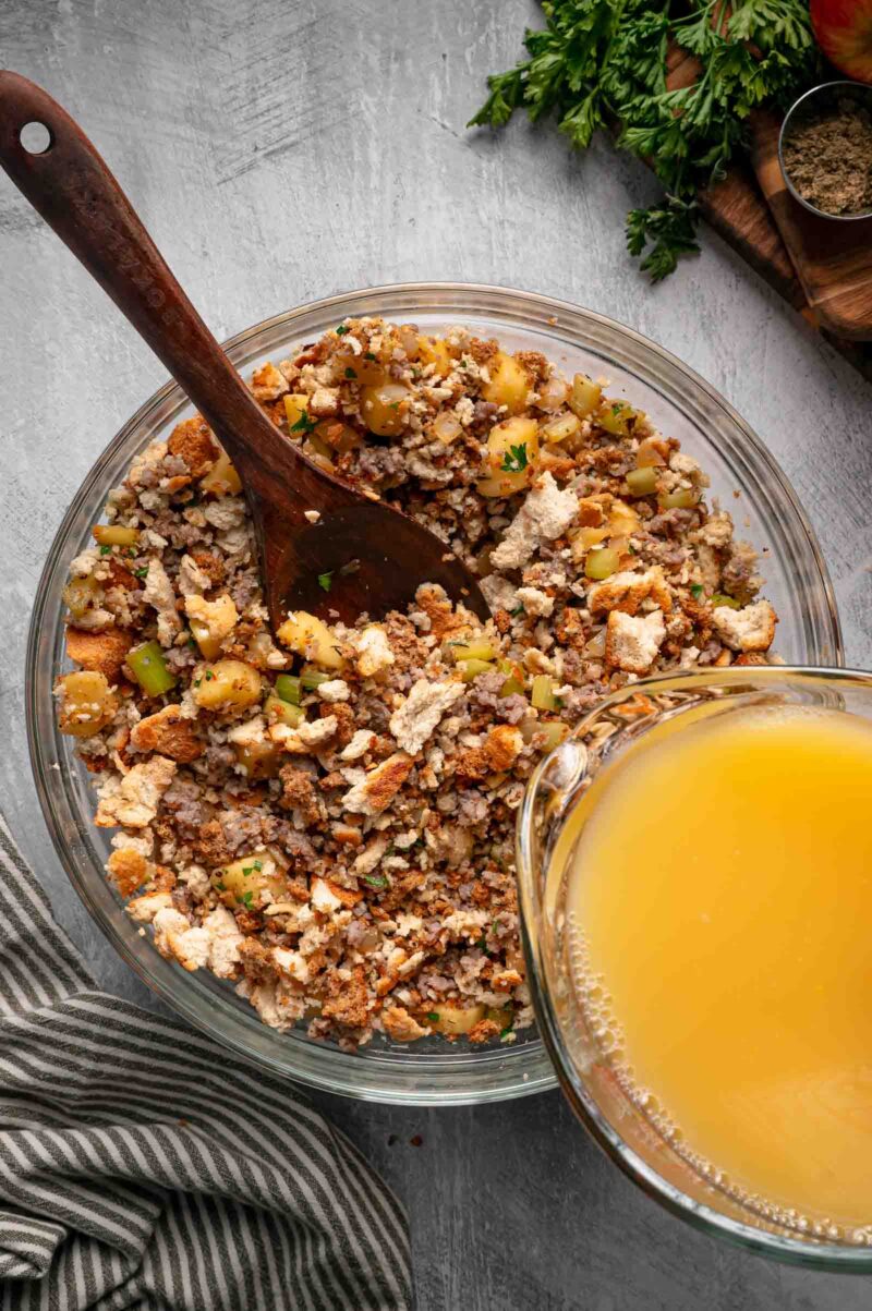 The whisked broth and egg mixture poured over the stuffing cubes, sausage and apples a cup at a time.
