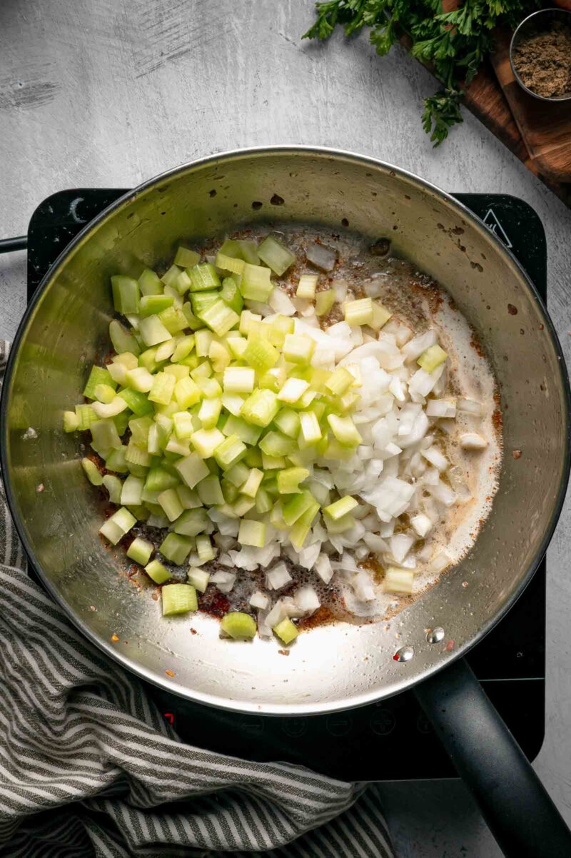 Diced celery and onion added to the melted butter in the skillet, ready to soften.