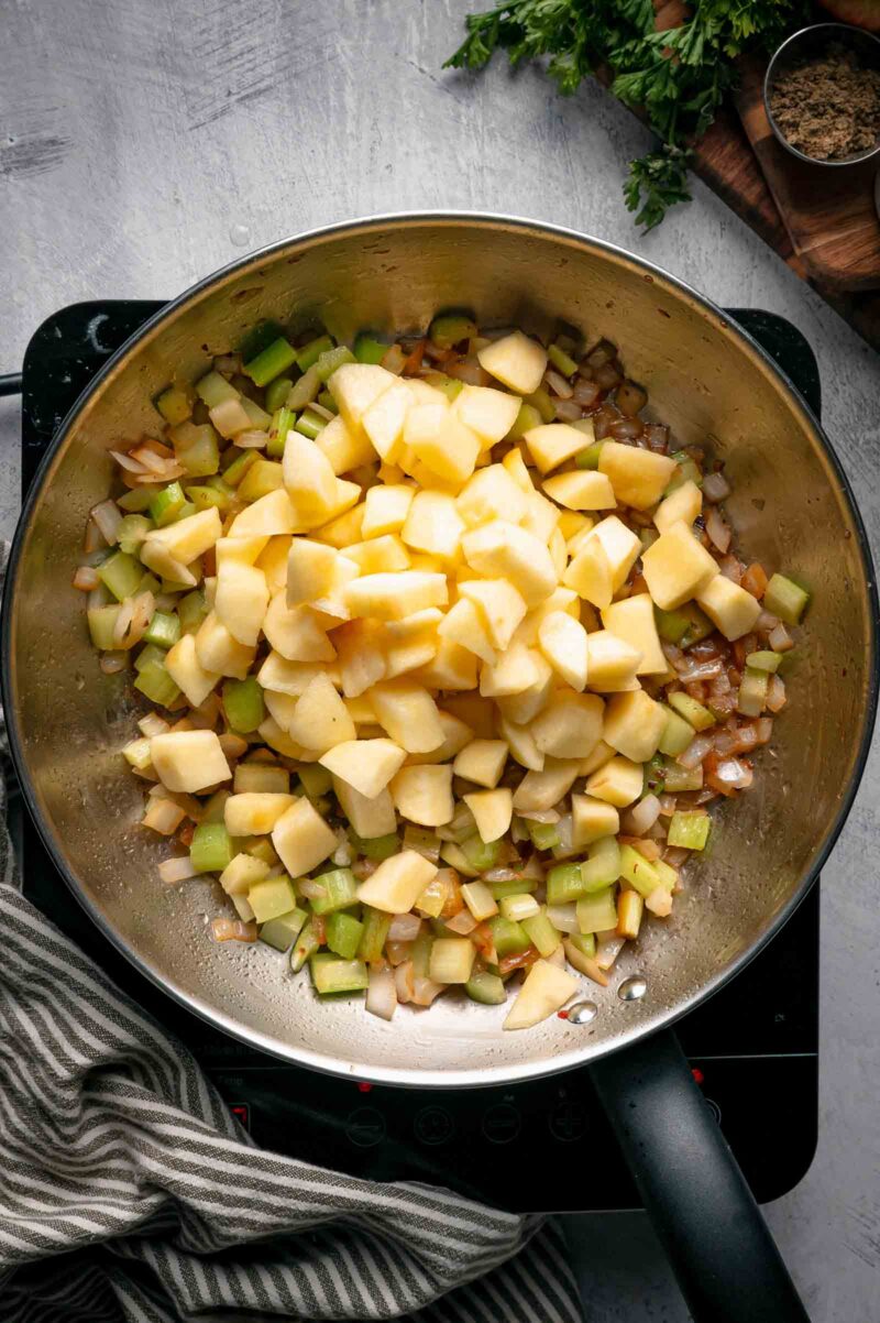 Peeled, half inch diced Honeycrisp apples piled on top of the softened celery and onion in the skillet.