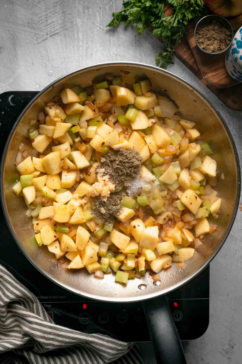 Minced garlic, rubbed sage, thyme, salt and pepper added to the apples, celery and onion to bloom in the fat.
