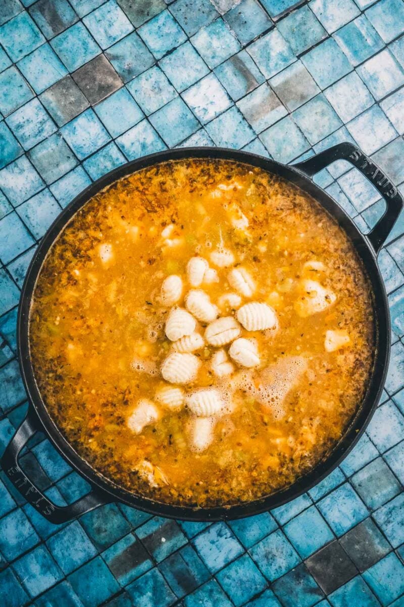 Potato gnocchi dropped into the simmering broth, floating among the chicken and vegetables.