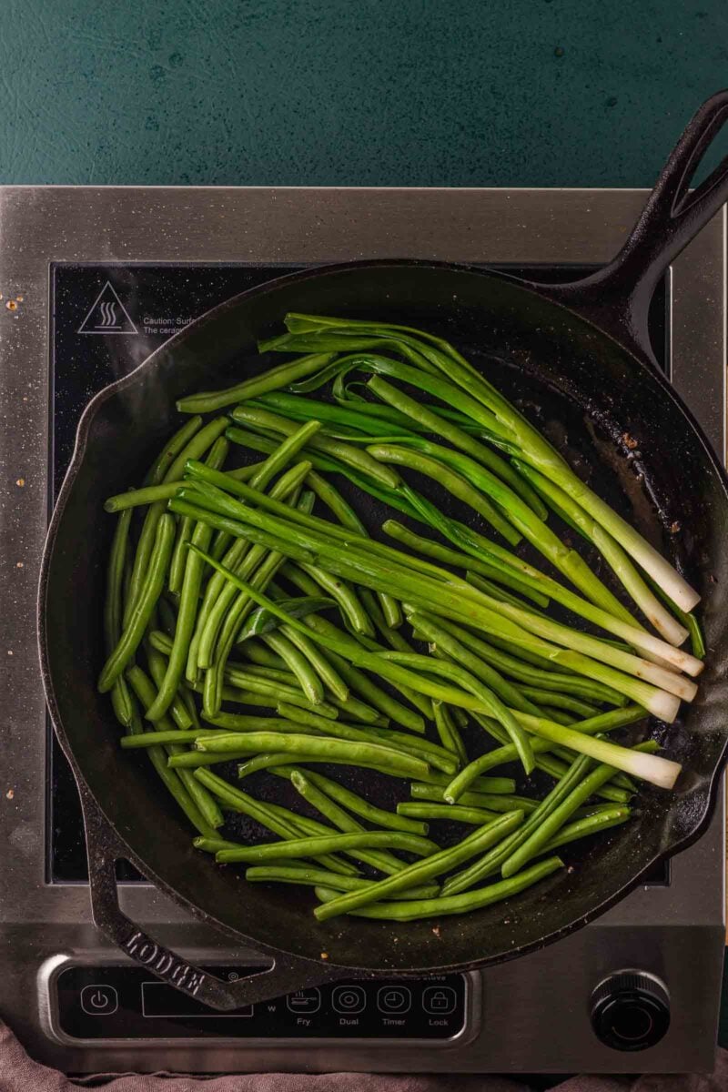 Green beans and whole scallions added to the same cast iron skillet to blister after the steak bites come out.