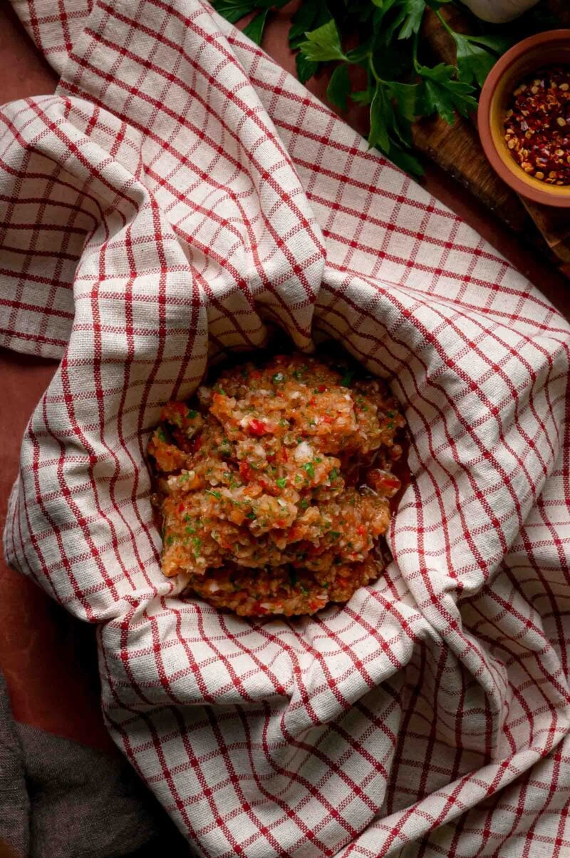 The pulsed pepper and onion mixture wrung out in a kitchen towel to squeeze the water out.