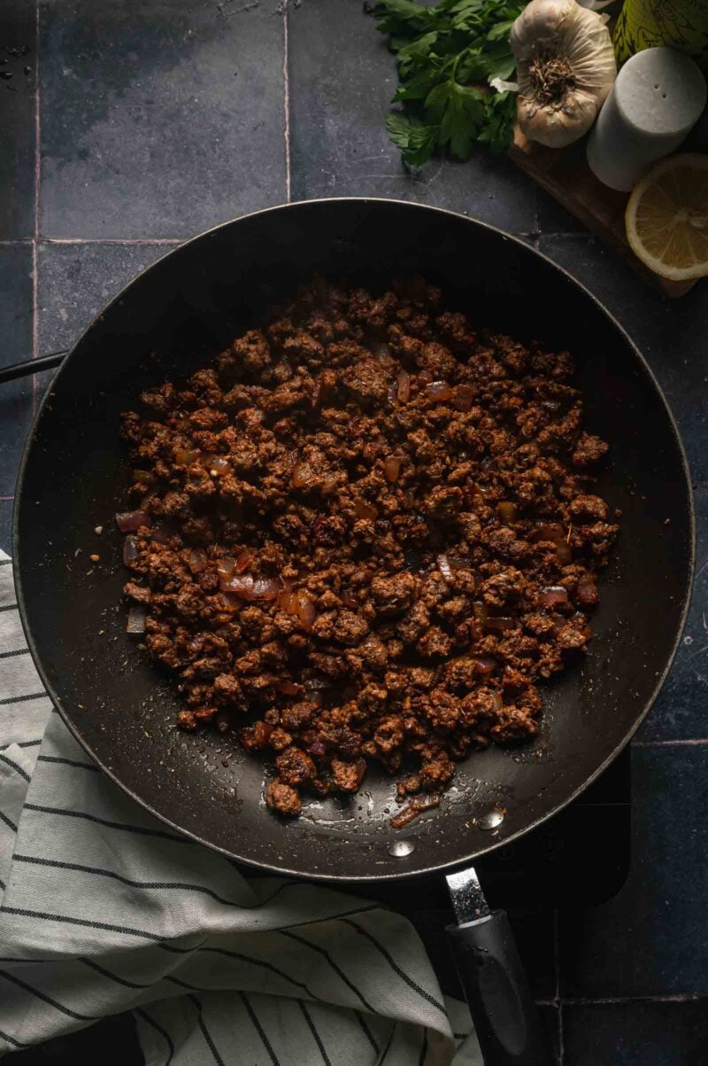 The finished spiced ground lamb, glossy and deeply browned with no liquid left pooling in the skillet.