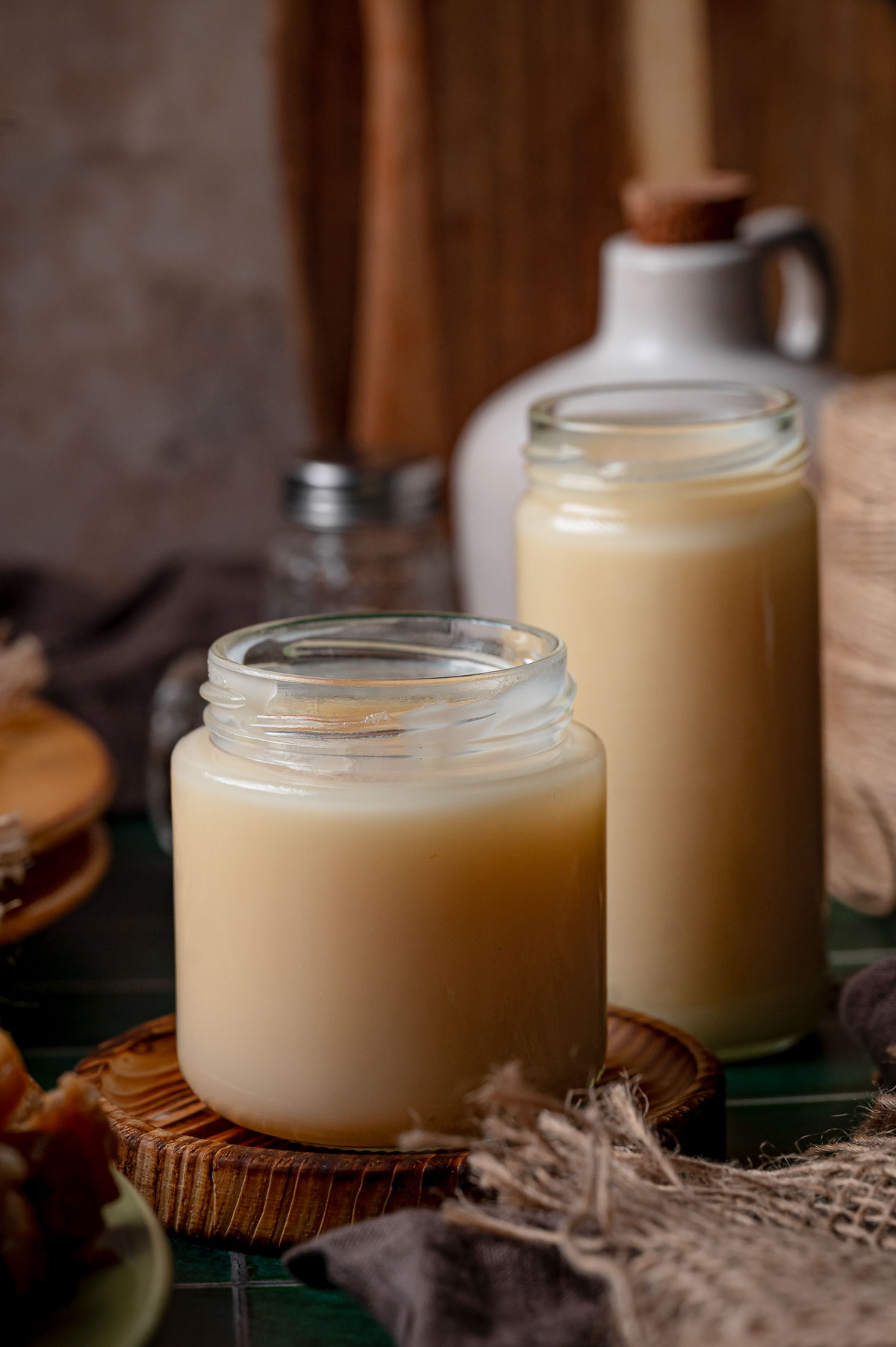 Two glass jars of rendered lard set solid and pale after chilling, the finished yield from three pounds of pork fat.