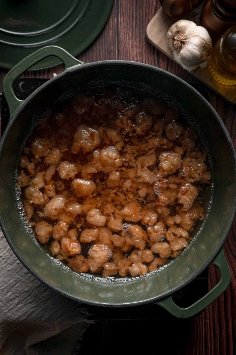 Beef tallow near the end of the render, the solids turned light golden brown and bubbling gently in clear amber fat.