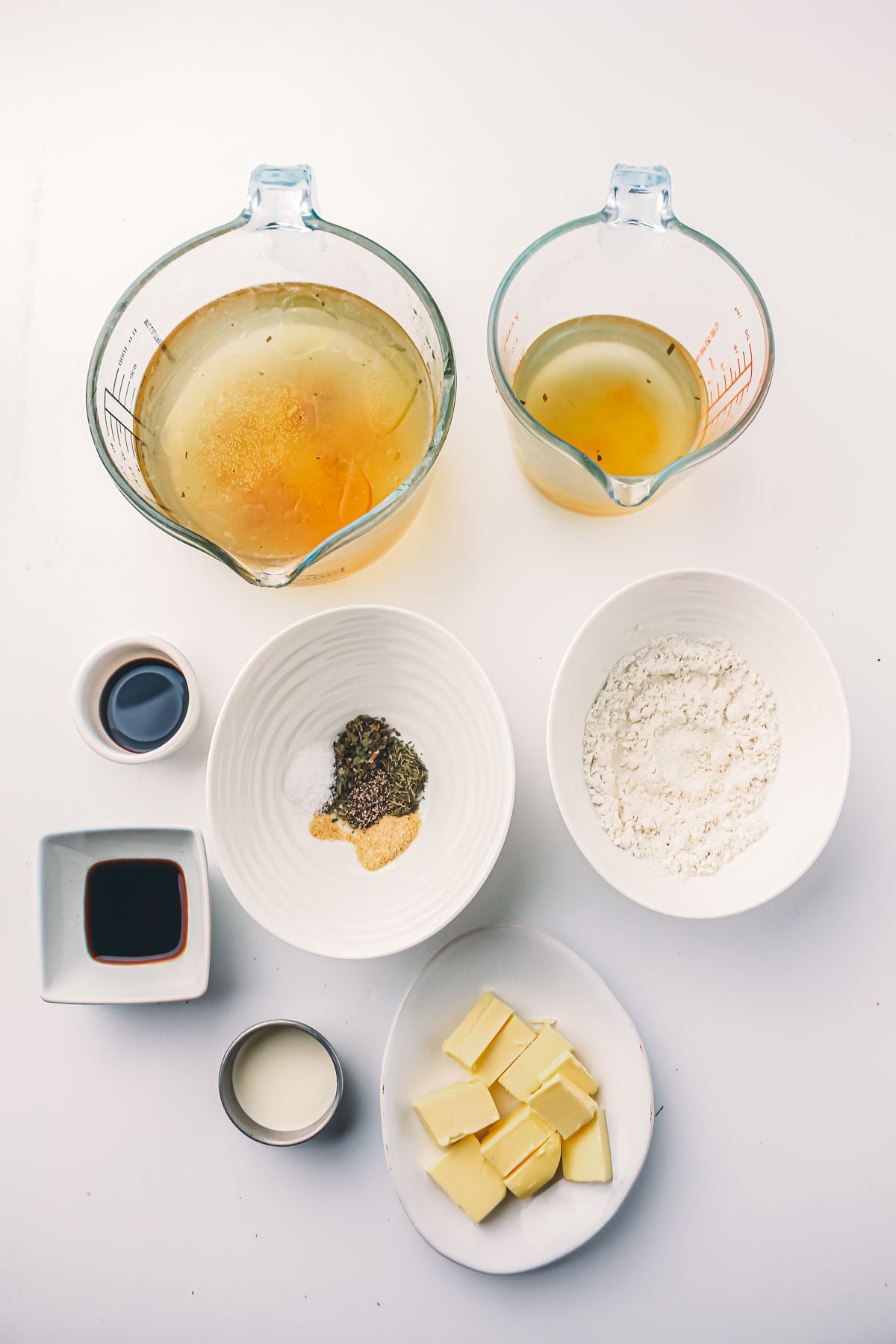 Ingredients for make ahead turkey gravy: turkey stock and chicken broth, butter, flour, soy sauce, Worcestershire, cream and dried herbs.