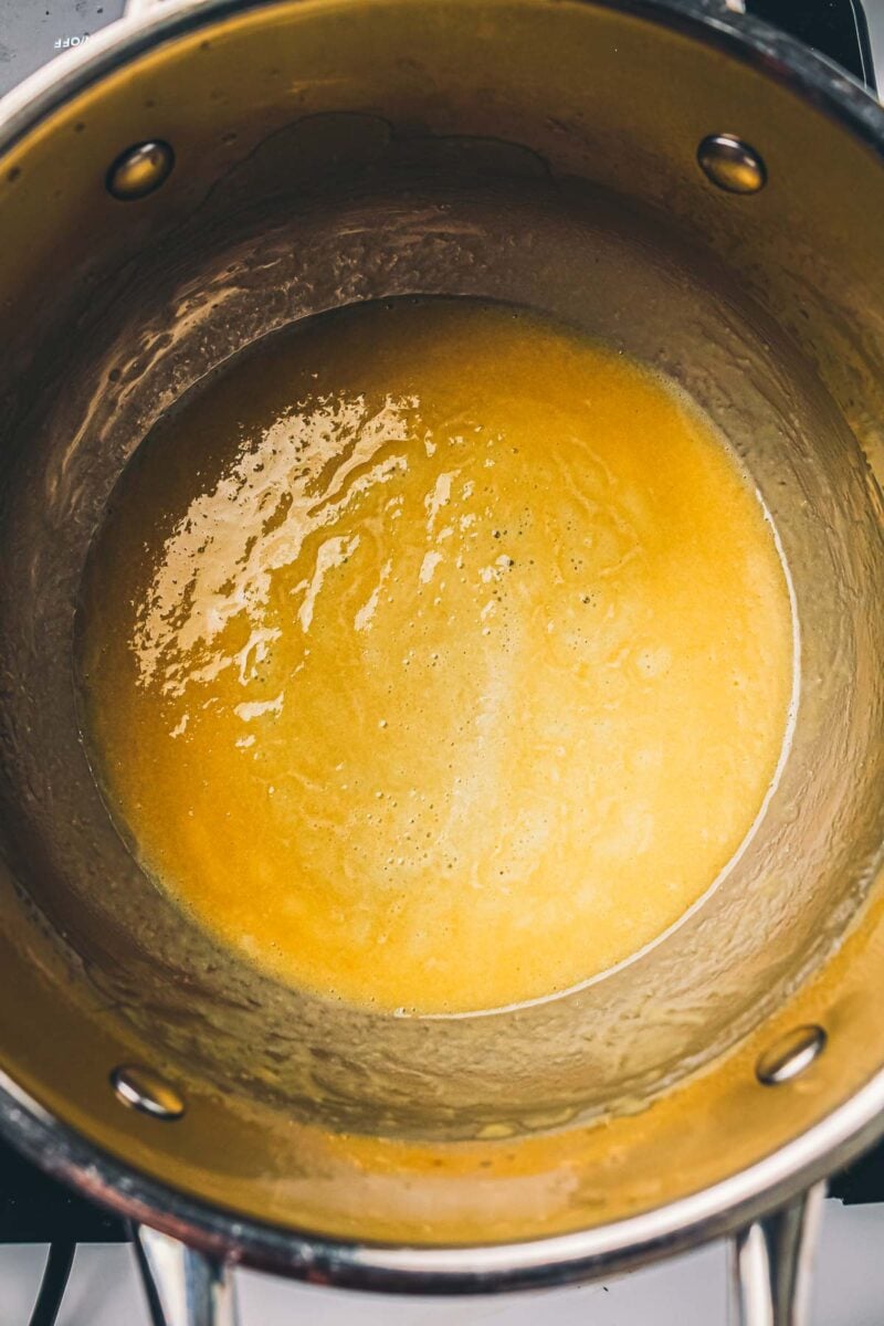 The roux whisked smooth and pale gold in the saucepan after cooking for two to three minutes.