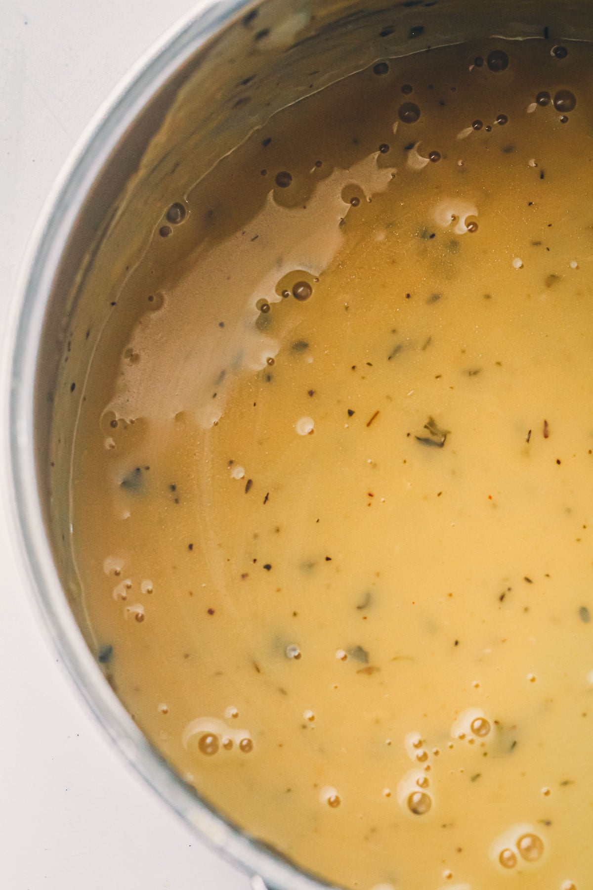 The finished make ahead turkey gravy in the pan, glossy and thick enough to coat the back of a spoon.