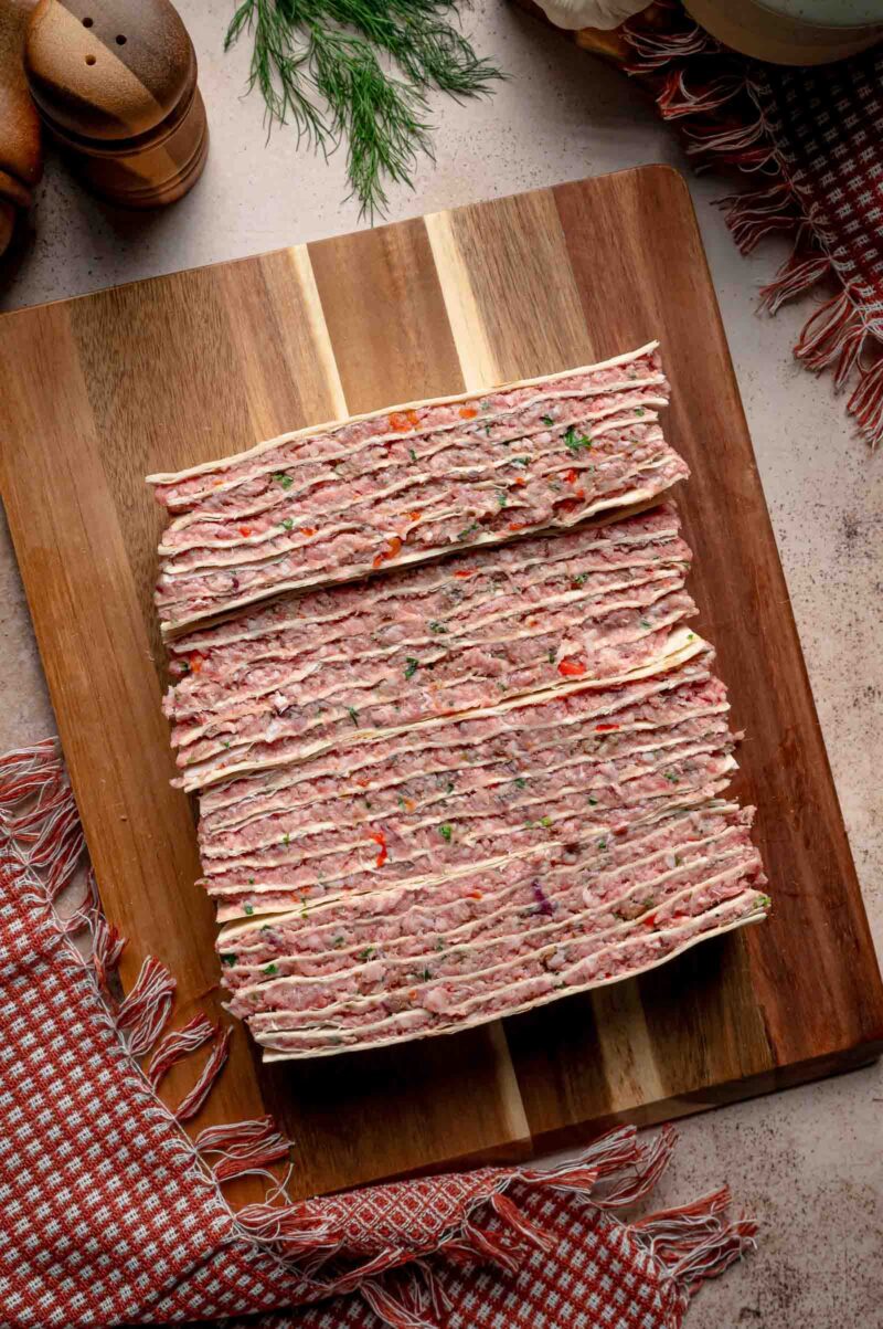 The four strips turned onto their cut sides so the alternating tortilla and meat layers stand vertically.