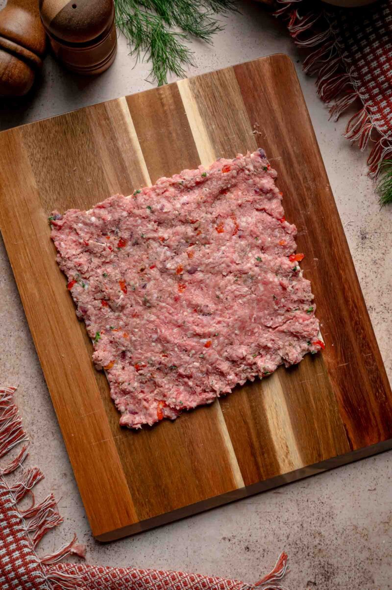 The lamb and beef mixture spread in a thin, even layer all the way to the edges of the squared tortilla.