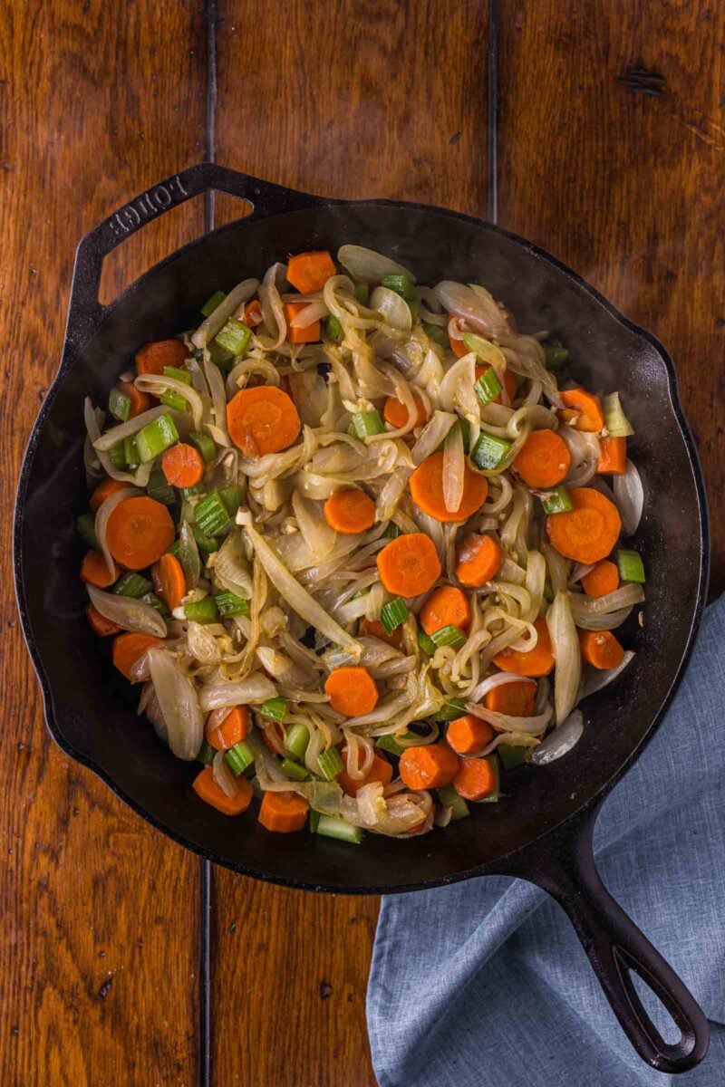 Carrots, celery and onion softened and browning at the edges in the beef drippings left in the cast iron skillet.