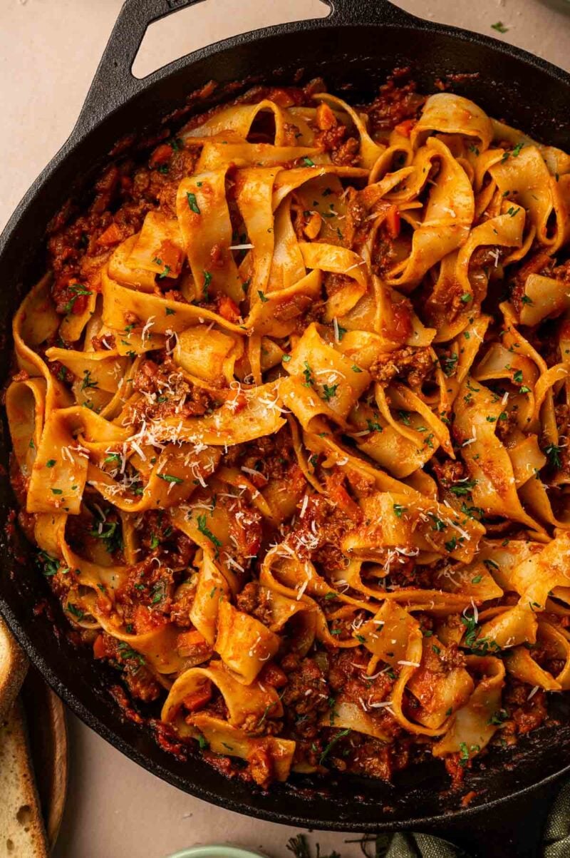 Pappardelle tossed in lamb bolognese in the skillet, topped with grated Parmesan and chopped parsley.